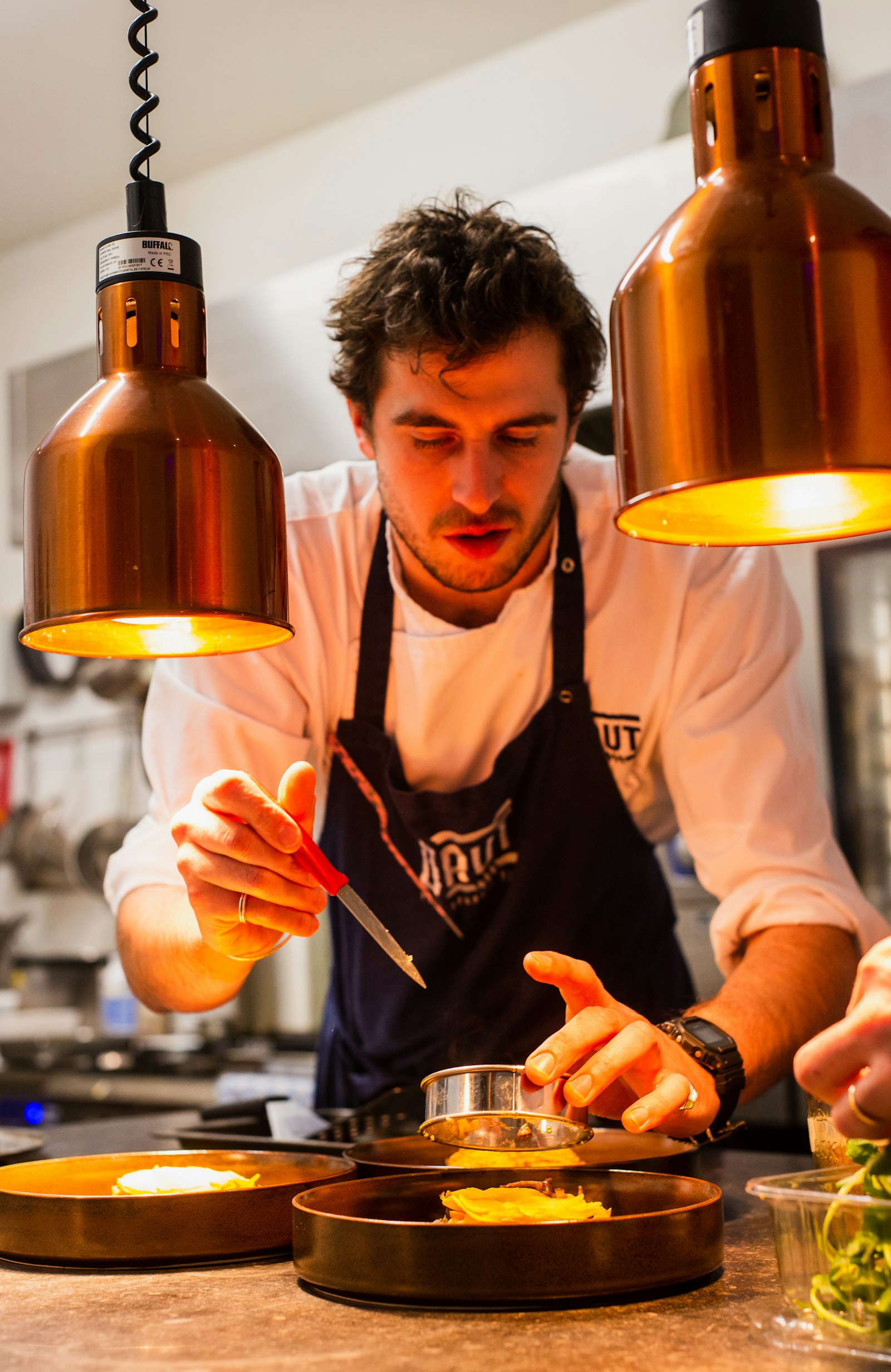 Chef finishing a plated dish